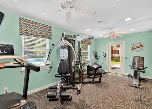A gym with a treadmill, elliptical machines, and other exercise equipment at Sawbranch Apartments, Summerville 29485