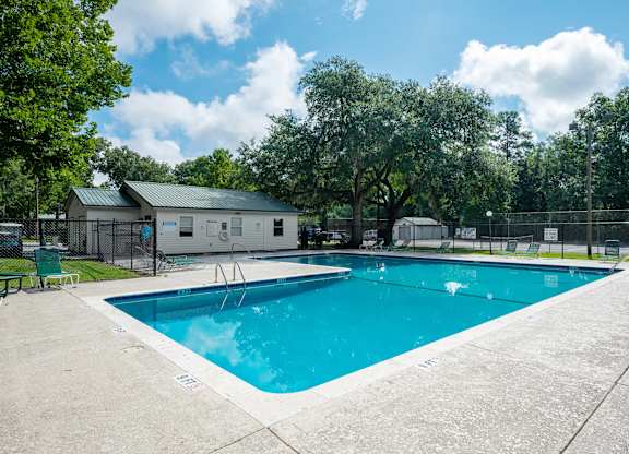 A large swimming pool surrounded by a fence and trees at Sawbranch Apartments, South Carolina, 29485