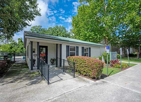 A small building with a green roof and a sign with a wheelchair symbol in front of it at Sawbranch Apartments, Summerville, South Carolina