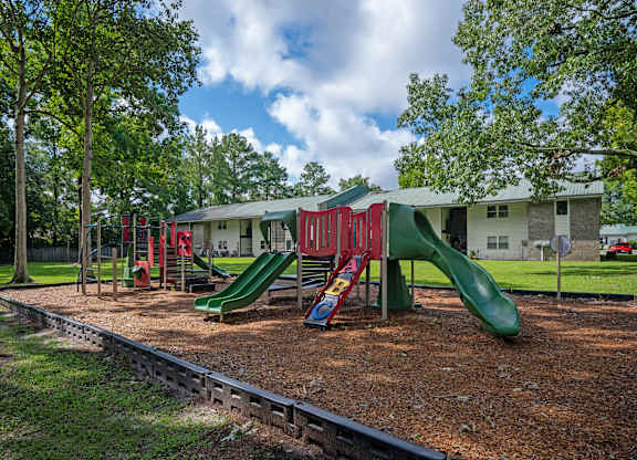 A playground with a green slide and red and green swings at Sawbranch Apartments, Summerville, SC