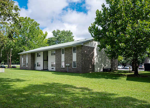 A building with a green lawn in front of it at Sawbranch Apartments, Summerville, SC