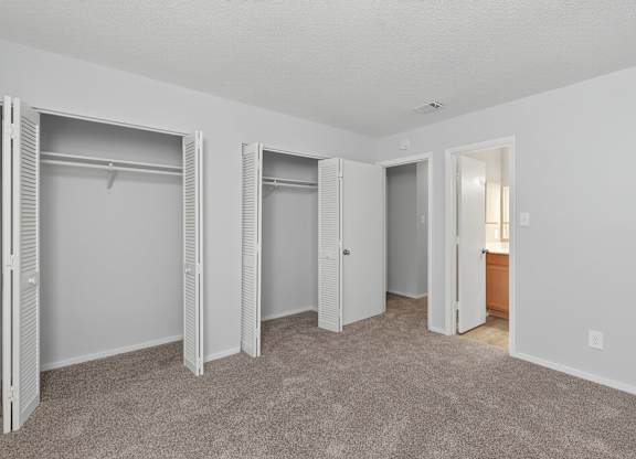 A room with white walls and carpeted floor with three open closets at Sawbranch Apartments, Summerville 29485