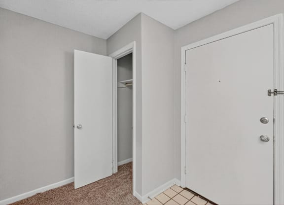 A room with a white door and a white closet with a shelf inside at The Landing Townhomes Apartments, Hanahan, SC