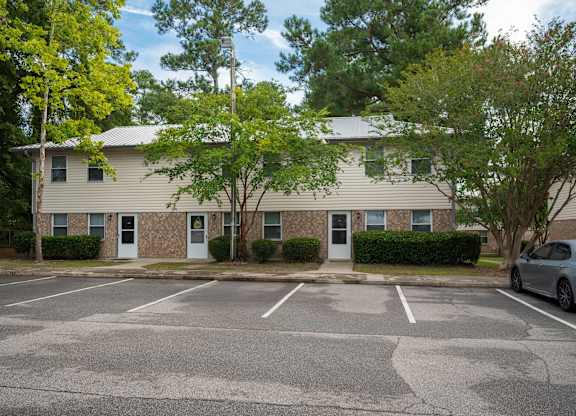 A parking lot in front of a two-story apartment building at Woodlocke Apartments, Moncks Corner, South Carolina