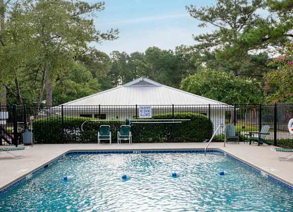 A pool with a white tent in the background at Woodlocke Apartments, Moncks Corner, South Carolina
