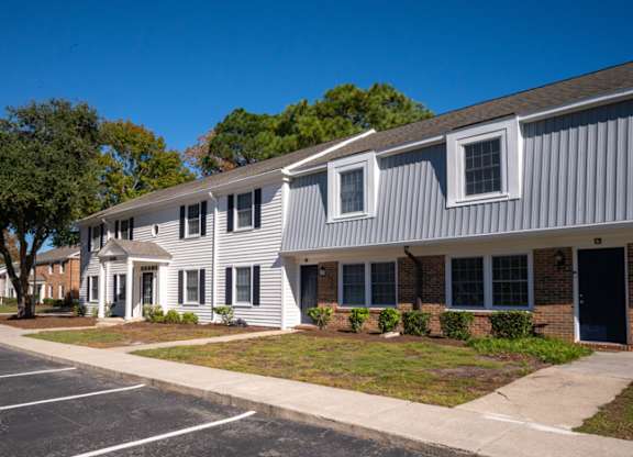 A building with a grey and white exterior is shown at The Preserve at Pine Valley Apartments, Wilmington, NC, 28412