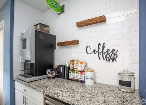 A coffee bar with a black fridge and a white counter at The Preserve at Pine Valley Apartments, Wilmington