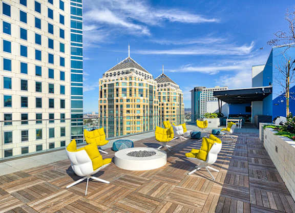 A rooftop patio with yellow chairs and a fire pit.at Eleven Fifty Clay Street, California, 94607