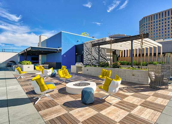 A modern outdoor seating area with yellow chairs and a white table.at Eleven Fifty Clay Street, California  