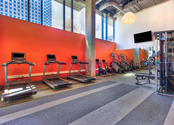 A gym with treadmills, weights and a television.at Eleven Fifty Clay Street, California  