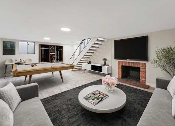 A living room with a grey couch, a coffee table, a fireplace, and a television. at The Lex At Lowry, Denver, CO