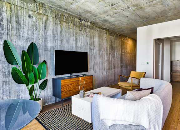 A living room with a white couch and a wooden cabinet.at Eleven Fifty Clay Street, Oakland  