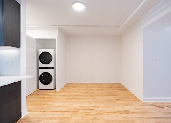 A room with a white wall and a wooden floor.