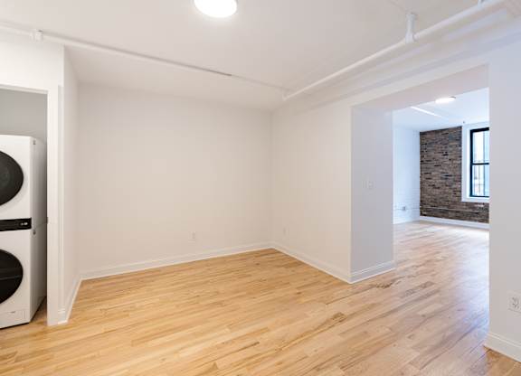 A room with wooden flooring and white walls.