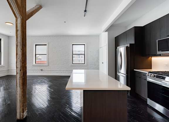 A kitchen with a white countertop and black cabinets.