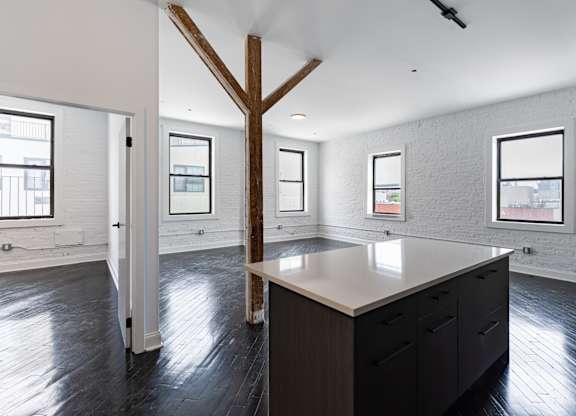 A large kitchen with a long island and a wooden beam on the ceiling.