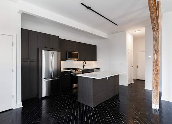 A modern kitchen with a large island and stainless steel appliances.
