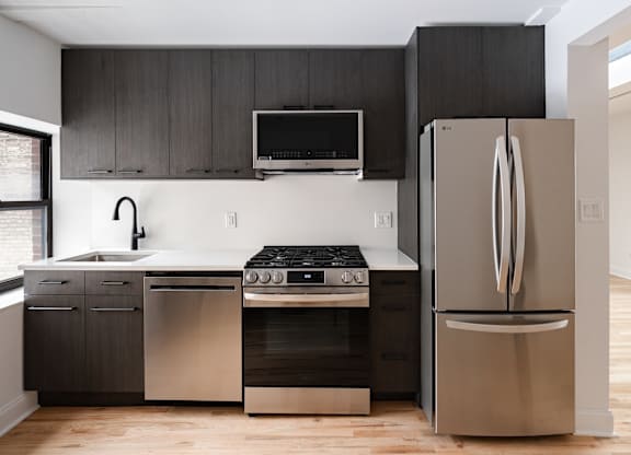 A modern kitchen with a stainless steel refrigerator and oven.
