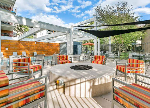 A patio with a fire pit and chairs. at The Lex At Lowry, Denver