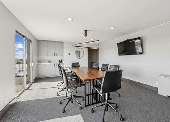 A conference room with a long table and chairs. at The Lex At Lowry, Denver, CO, 80224