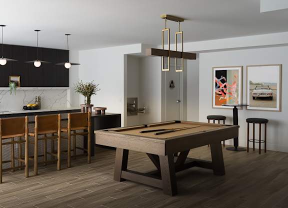 A modern kitchen with a pool table in the middle.