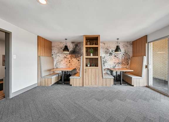 A room with a grey carpet and a wooden bookshelf. at The Lex At Lowry, Denver, 80224