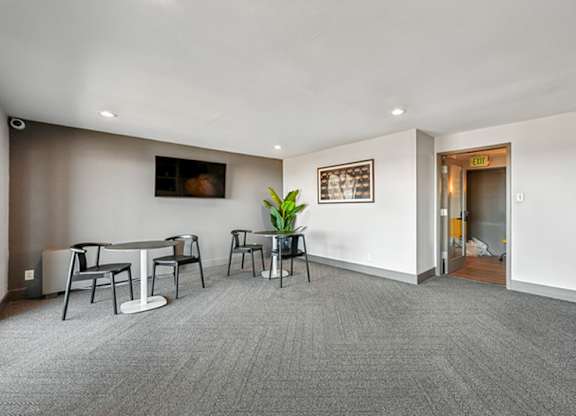 A conference room with a table and chairs and a plant. at The Lex At Lowry, Denver