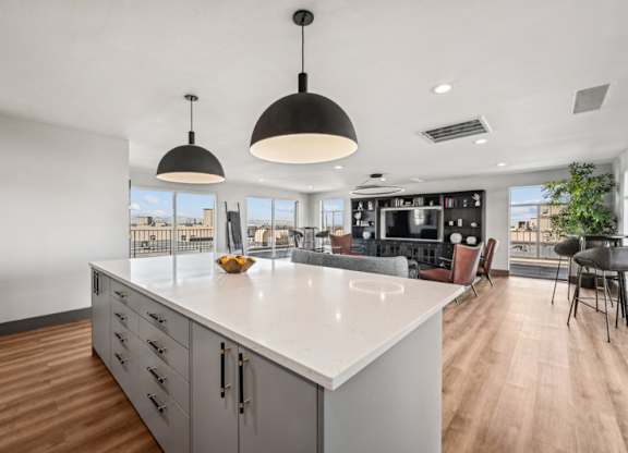 A modern kitchen with a large island and pendant lights. at The Lex At Lowry, Denver