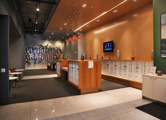 A reception area with a wooden counter and a TV mounted on the wall.at Prizma, California, 90038