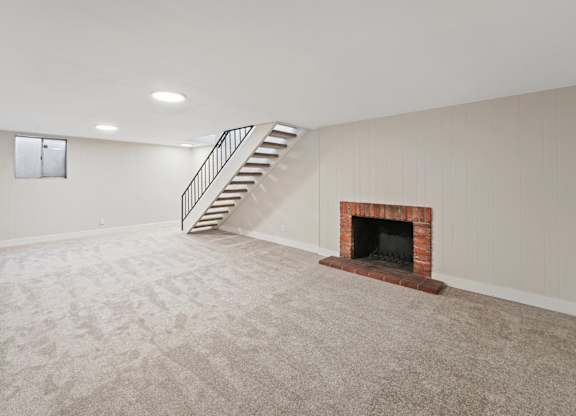 A room with a fireplace and a staircase. at The Lex At Lowry, Colorado, 80224