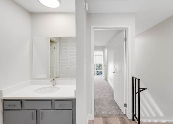 A bathroom with a sink, mirror, and cabinets. at The Lex At Lowry, Denver, CO, 80224