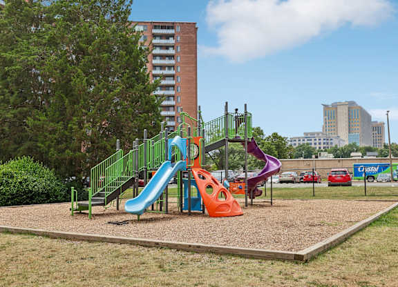 A playground with a green slide and a purple slide.