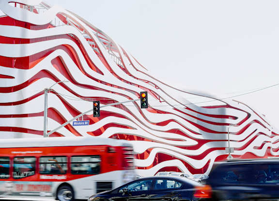  Red and white bus is driving at 701 Hudson, Los Angeles, CA, 90005