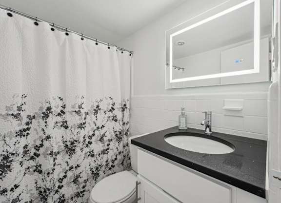 A Bathroom With a Floral Shower Curtain at Ashlawn at Southern Towers, Alexandria, 22311