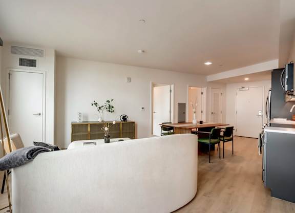 A modern living room with a white sofa and a wooden floor.at Channel House, Oakland, CA 94607