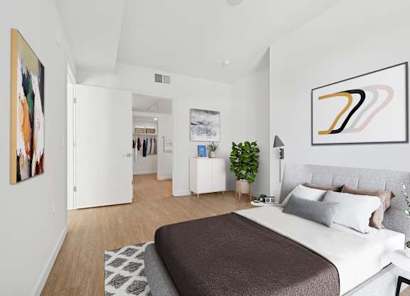 A bedroom with a large bed and a painting on the wall at Coro Apartments, Los Angeles