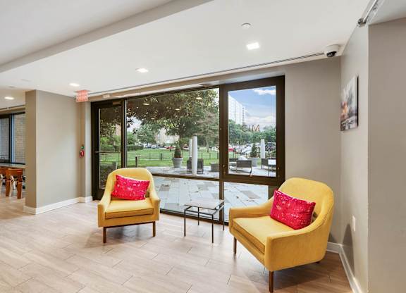 Two yellow chairs with red pillows in clubroom at The Graham at Southern Towers, Alexandria, 22311