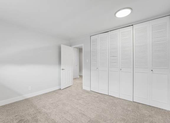 A room with white cupboards and a carpeted floor. at The Lex At Lowry, Denver, Colorado