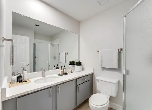 A white toilet sits next to a sink in a bathroom. at The Lex At Lowry, Denver, 80224
