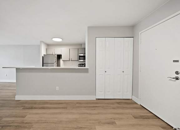 A kitchen with white cabinets and a white door. at The Lex At Lowry, Denver, CO