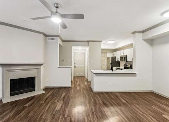 A living room with a fireplace and a ceiling fan.at Onyx183, Austin, TX 78729  