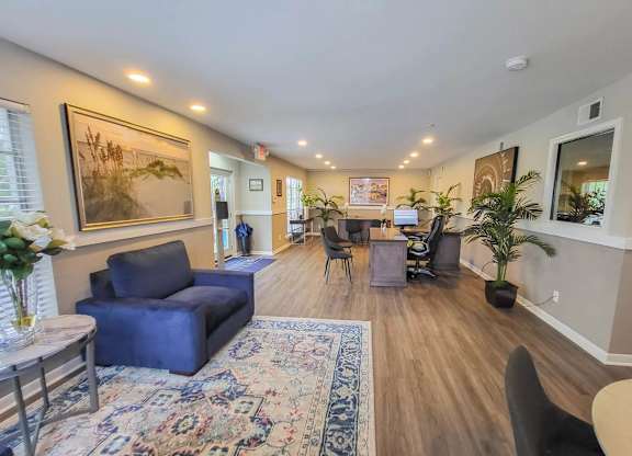 A living room with a blue couch and a rug.