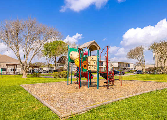 A playground with a slide and a swing set.