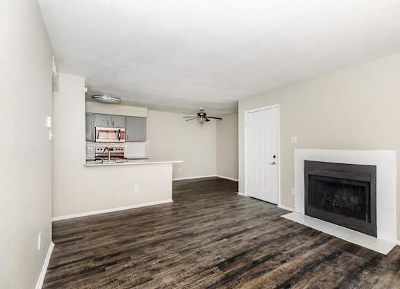 Open layout living space with kitchen and fireplace at Park at LeBlanc Apartments, Fort Worth, 76132
