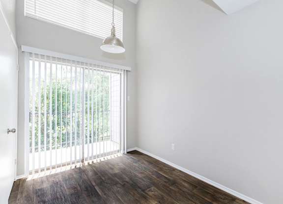 Empty room with vertical blinds and pendant light at Park at LeBlanc Apartments, Texas
