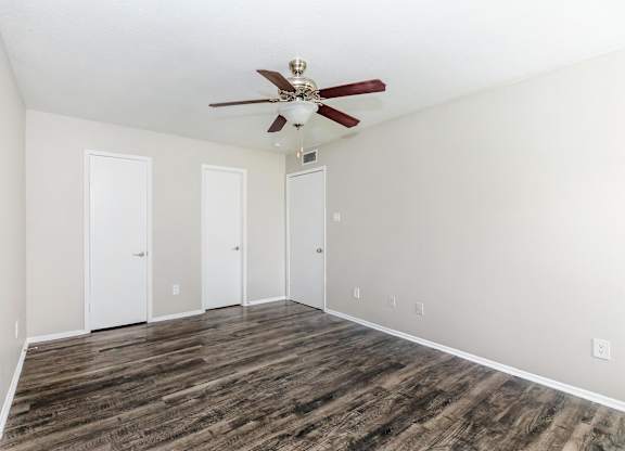 Empty bedroom with ceiling fan and wood style flooring at Park at LeBlanc Apartments, Fort Worth, TX 76132