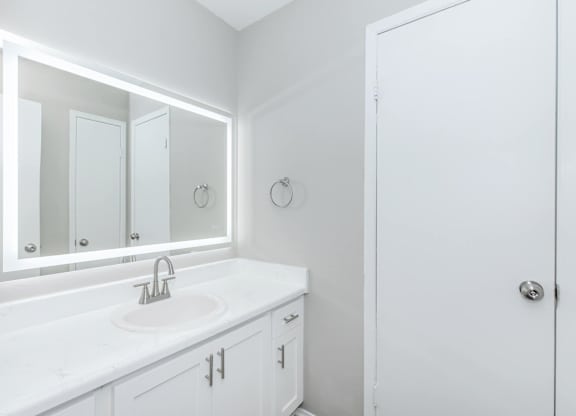 Modern bathroom with backlit mirror and white vanity at Park at LeBlanc Apartments, Fort Worth, TX 76132