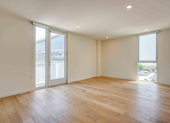 A room with wooden flooring and sliding glass doors.at Prizma, Los Angeles, CA  