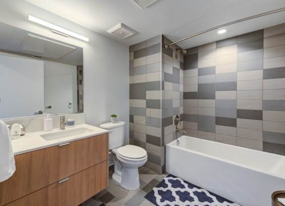 A bathroom with a white toilet, sink, and bathtub.at Prizma, Los Angeles California  