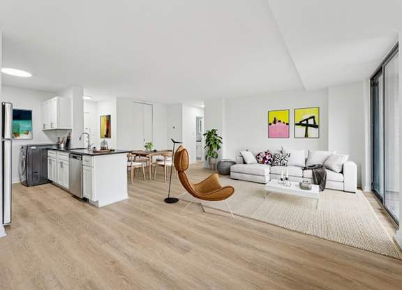 A modern living room with a white couch and a wooden chair.at Sherwood at Southern Towers, Alexandria, 22311